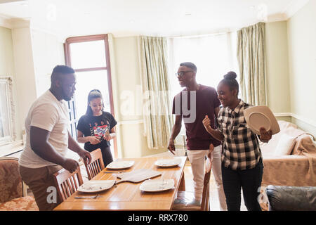 Fratelli adolescenti impostazione tavolo da pranzo Foto Stock