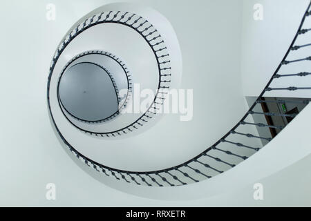 Da sotto moderne scale a spirale con ringhiera nero in ambienti interni Foto Stock