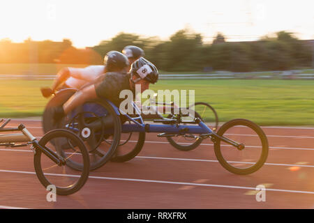 Gli atleti paraplegici accelerando lungo la via dello sport in carrozzella gara Foto Stock
