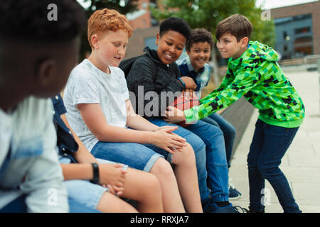 Tween ragazzi con basket in schoolyard Foto Stock