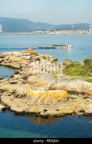 Rias Baixas seascape con Punta Faro Cabalo e barca di cozze Foto Stock