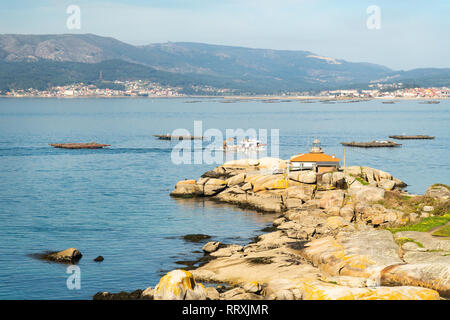 Rias Baixas seascape con Punta Faro Cabalo e barca di cozze Foto Stock