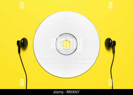 CD vuoto e cuffie su sfondo giallo Foto Stock