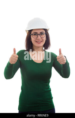 Giovane donna ingegnere costruzione indossando occhiali protettivi e mostrando hardhat Thumbs up gesto positivo isolato su sfondo bianco. Foto Stock