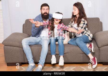 Sacco di preoccupazione che circondano i bambini utilizzando gli auricolari VR. Figlia bloccato in realtà virtuale. Il mondo digitale. Vita virtuale e di dipendenza. I genitori preoccuparsi di capretto in realtà virtuale. Virtual cyber gaming. Foto Stock