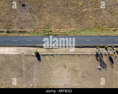 Country Road Australia dal di sopra con una strada a due corsie, alberi e in un ambiente naturale di verde e marrone impostazione. Foto Stock
