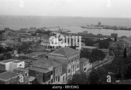 Griechenland, Grecia - Blick auf den Hafen und die Küstenlinie einer kleinen Stadt in Griechenland, 1950er Jahre. Vista del porto e della linea costiera di una piccola cittadina, Grecia, 1950s. Foto Stock