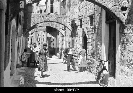 Griechenland, Grecia - Menschen in einer kleinen Gasse auf Rhodos, Griechenland 1950er Jahre. Persone in un piccolo vicolo di Rodi, Grecia, 1950s. Foto Stock