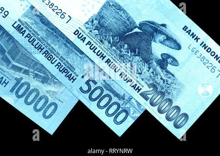 Diversi rupiah indonesiano banconote da vicino. Colore blu tonica Foto Stock