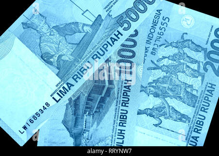 Diversi rupiah indonesiano banconote da vicino. Colore blu tonica Foto Stock