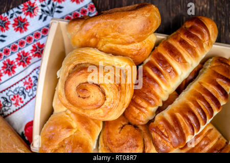 Deliziosi piatti appetitosi rubicondo cotto smaltato panini, torte e dolci con la cannella e vari ripieni, realizzato da premium organic farina, steso su un woo Foto Stock