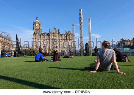 Edinburgh, Regno Unito. Il 27 febbraio 2019. Le persone che si godono il sole in Waverley Mall giardino con il Balmoral Hotel. Credito: Craig Brown/Alamy Live News Foto Stock