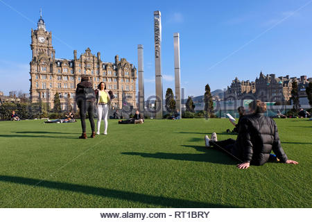 Edinburgh, Regno Unito. Il 27 febbraio 2019. Le persone che si godono il sole in Waverley Mall giardino con il Balmoral Hotel. Credito: Craig Brown/Alamy Live News Foto Stock