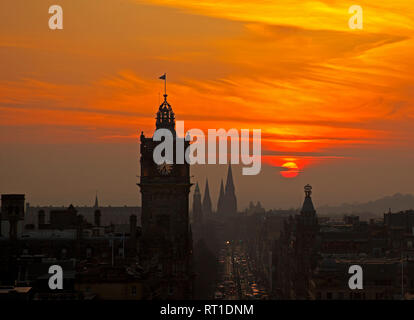 Edimburgo, Scozia, 27 febbraio 2019. Tempo del Regno Unito, tramonto spettacolare sul centro della città dopo una giornata molto soleggiata e frizzante di temperature che salgono a 16 gradi. Tuttavia, si prevede che le nuvole rotolino in questa sera e le temperature scendono a più normale per il periodo dell'anno. Foto Stock