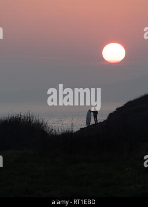 Pembrokeshire, Wales, Regno Unito. Il 27 febbraio, 2019. Ultimo giorno sulle onde come il sole tramonta e tempo caldo termina in corrispondenza di Manorbier Beach, Pembrokeshire West Wales UK Wednesay 27 febbraio 2019 Credit: dayslikethis/Alamy Live News Foto Stock