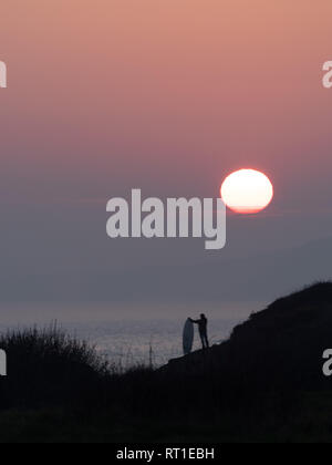 Pembrokeshire, Wales, Regno Unito. Il 27 febbraio, 2019. Ultimo giorno sulle onde come il sole tramonta e tempo caldo termina in corrispondenza di Manorbier Beach, Pembrokeshire West Wales UK Wednesay 27 febbraio 2019 Credit: dayslikethis/Alamy Live News Foto Stock