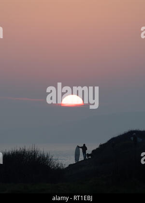 Pembrokeshire, Wales, Regno Unito. Il 27 febbraio, 2019. Ultimo giorno sulle onde come il sole tramonta e tempo caldo termina in corrispondenza di Manorbier Beach, Pembrokeshire West Wales UK Wednesay 27 febbraio 2019 Credit: dayslikethis/Alamy Live News Foto Stock