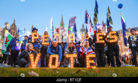 Westminster, Londra 27 Feb 2019. Un voto popolare Veglia di luce è stata organizzata da rimanere i tifosi di diverse realtà regionali Anti-Brexit gruppi in tutto il paese al di fuori del Parlamento, tenendo accesa la lettera 'Ortografia voto popolare". Si passa quindi alle porte della House of Commons, in onda UE bandiere, striscioni e Bastoncini leggeri. Credito: Imageplotter/Alamy Live News Foto Stock