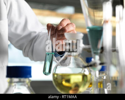 Scienziato tenendo il tubo di prova durante un esperimento in laboratorio Foto Stock