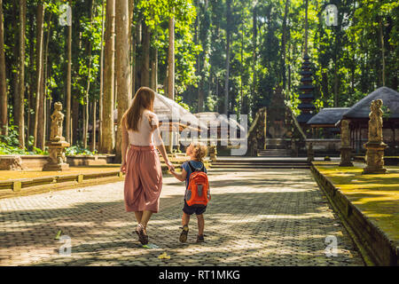 Madre e figlio i viaggiatori alla scoperta della foresta Ubud nella foresta delle scimmie, Bali Indonesia. Viaggiare con bambini di concetto Foto Stock