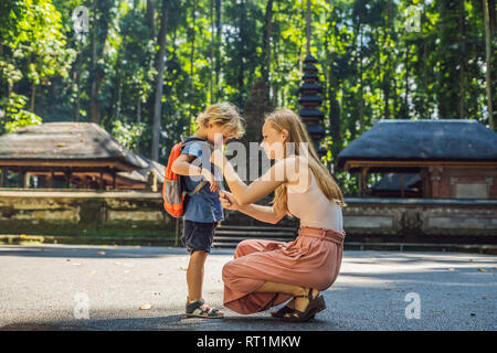 Madre e figlio i viaggiatori alla scoperta della foresta Ubud nella foresta delle scimmie, Bali Indonesia. Viaggiare con bambini di concetto Foto Stock