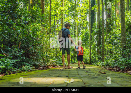 Papà e figlio viaggiatori alla scoperta della foresta Ubud nella foresta delle scimmie, Bali Indonesia. Viaggiare con bambini di concetto Foto Stock