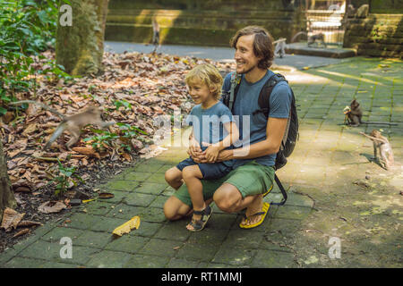 Papà e figlio viaggiatori alla scoperta della foresta Ubud nella foresta delle scimmie, Bali Indonesia. Viaggiare con bambini di concetto Foto Stock