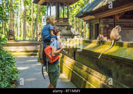 Papà e figlio viaggiatori alla scoperta della foresta Ubud nella foresta delle scimmie, Bali Indonesia. Viaggiare con bambini di concetto Foto Stock