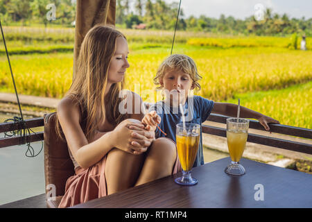 Madre e figlio bere un drink in un riso Terrace cafe, Bali Ubud Foto Stock