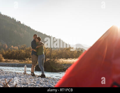 Coppia matura campeggio al Riverside nella luce della sera Foto Stock