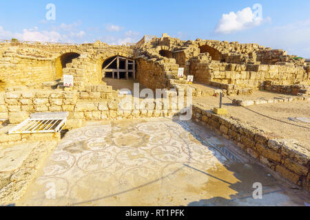 Vista della casa romana e il mosaico in Cesarea National Park, Nord di Israele. Segno sono trilingui segni di avvertenza Foto Stock