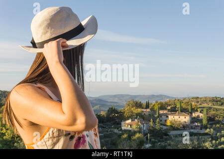 L'Italia, Toscana, Siena, giovane donna godendo la vista ad un azienda vinicola Foto Stock