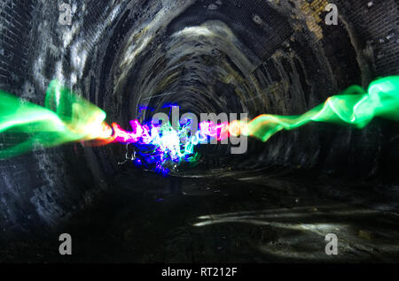 Luce astratta pittura arte creata verso il basso un ferroviarie dismesse tunnel in Inghilterra. Bella texture. Foto Stock