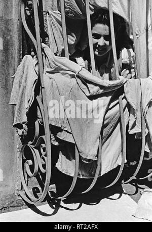 Erich Andres Italien - Smile attraverso la finestra sbarrata, Napoli, quartiere Santa Lucia, 1950s. Foto di Erich Andres Erich Andres - Italia, Italia, Napoli, Napoli, Santa Lucia, storia, storici degli anni cinquanta Italien - Ein freundliches Lächeln in Santa Lucia in Neapel. Foto Stock