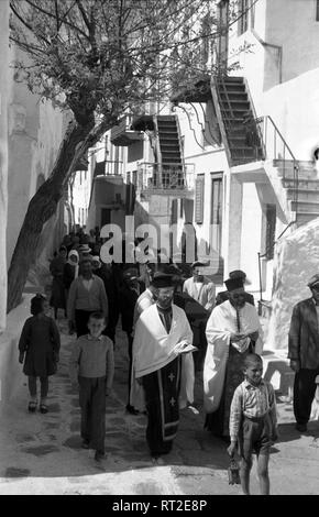 Griechenland, Grecia - Eine Beerdingungsprozession zieht sich durch die kleinen engen Gassen einer Kleinstadt in Griechenland, 1950er Jahre. Una processione funebre nel suo cammino attraverso i vicoli di una piccola città in Grecia, 1950s. Foto Stock