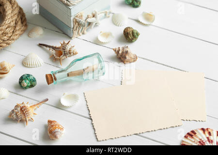 Nautica stile di vita voci: bottiglia con messaggio, conchiglie di mare, torace e vecchie foto vuota per l'interno. Concetto marino. Retrò tonica. Foto Stock