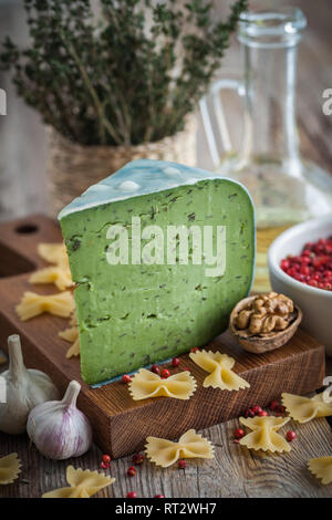 Pesto Verde formaggio con erbe e spezie sul tagliere, pasta e gli ingredienti per la pasta italiana La cucina. Retrò tonica foto. Foto Stock