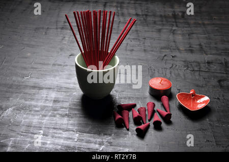 Bastoncini di incenso in urna su sfondo di legno Foto Stock