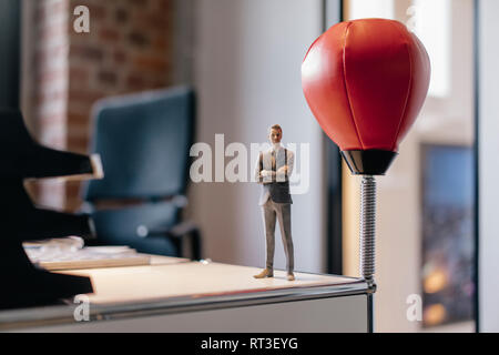 Imprenditore figurina in piedi sulla scrivania dalla sfera di punzonatura Foto Stock