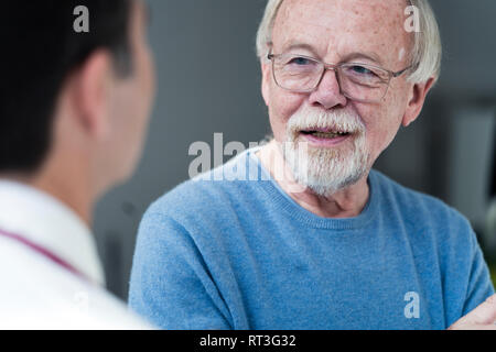 Senior paziente parla al medico nella pratica medica Foto Stock