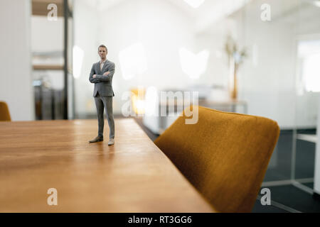 Imprenditore figurina in piedi sulla scrivania in ufficio moderno Foto Stock