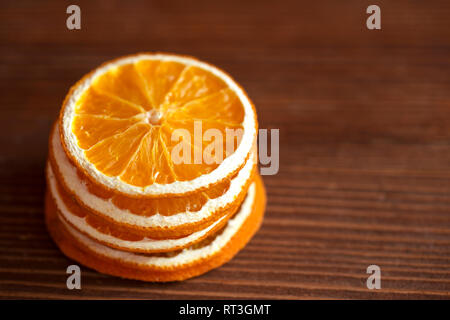 Asciugare le fette di colore arancione su sfondo di legno Foto Stock
