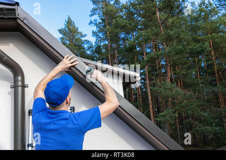 Copritetti installazione di metallo bordo antigoccia profilo sul tetto della casa Foto Stock