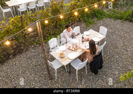 L'Italia, Toscana, Siena, coppia giovane avente una cena romantica in un vigneto Foto Stock