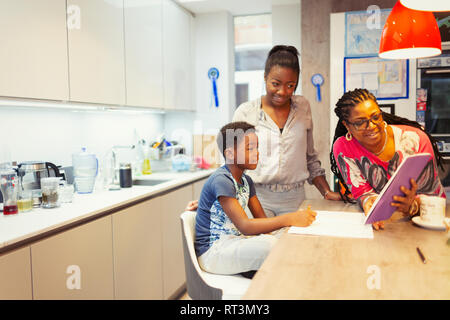 Famiglia con tavoletta digitale in cucina Foto Stock