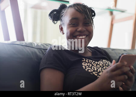 Ritratto sorridente, fiduciosi di tween girl texting con smart phone Foto Stock