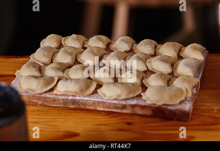 Gnocchi a crudo su un pannello di legno. Il processo di cottura Foto Stock