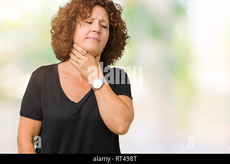 Bel mezzo ager senior donna sullo sfondo isolato toccando doloroso il collo, il mal di gola per influenza, zolla di terreno e infezione Foto Stock