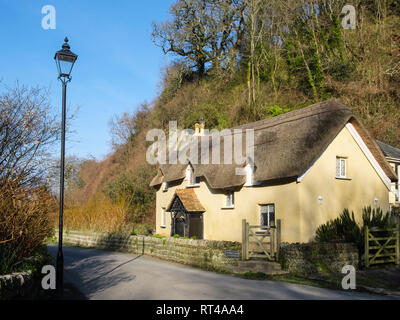 Xvii Secolo Vecchio cameriere Cottage 1653 con un tradizionale tetto di paglia nel grazioso paese di lingua inglese villaggio di Lee, North Devon, Inghilterra, Regno Unito, Gran Bretagna Foto Stock