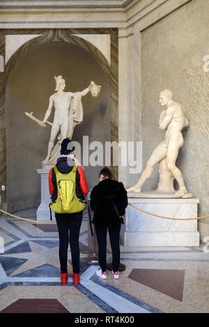 I turisti ammirare statue classiche incluse Perseo trionfante & Medusa di Antonio Canova (1757-1822) nel Cortile Ottagonale Musei Vaticani Foto Stock